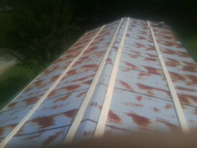 Rusted metal roof panels with new wood purlins before replacement — Storm Damage Roof Repair in Shiloh by Roofing Brothers